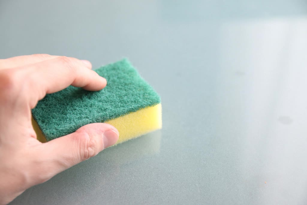 Cleaning a glass surface with a sponge